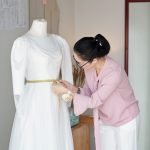Tailor creating dress for wedding of client